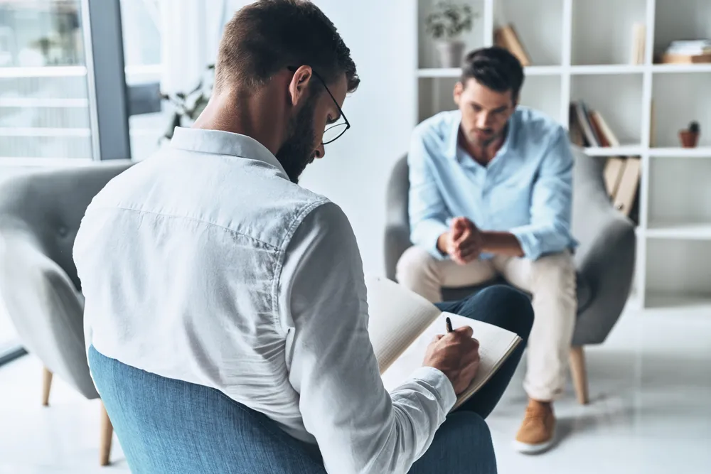 CBT therapy session - therapist and client in a calming office environment